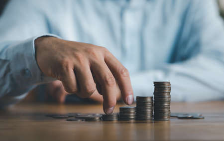 save and investment concept business finance growing idea, hand step forward on stacking of coins