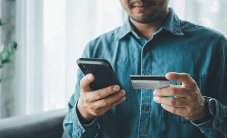 make payment with smartphone and credit card, Online payment or internet banking, man makes an online shopping by credit card payment on mobile smartphone, e commerce, e businessの写真素材