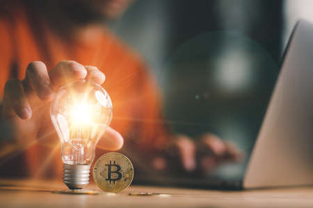 Good idea for cryptocurrency concept- digital market. man touching on lightbulb with Golden Bitcoins, Business and Finance, Savings, Investing with Digital Assetsの写真素材