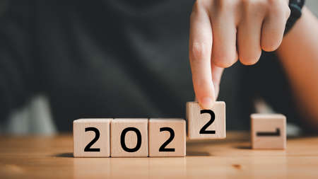 start to year 2022, hand hand putting wood cube for 2022 years. creative background for the new year. happy new years concept.の写真素材