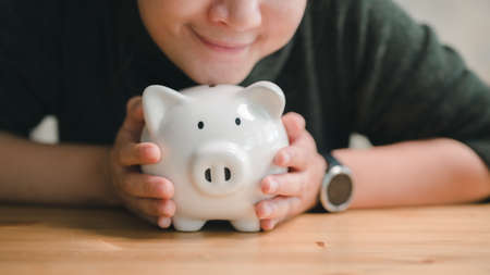 Happy woman saving money in a piggybank. saving money wealth and financial concept, Business, finance, investment, Financial planning.の写真素材