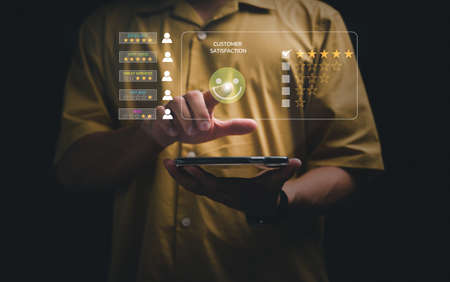 Casual Businessman choosing screen on the happy Smile face icon to give satisfaction in service, Customer service and Satisfaction concept, rating very impressed.の写真素材