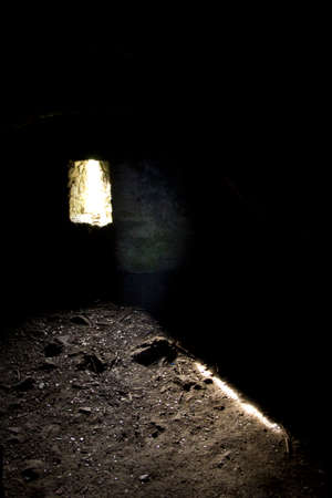 A ray of hope in dark dungeon pointed on groundの写真素材