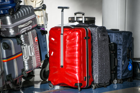 Red and black suitcases on wheels in airport, ready for travel