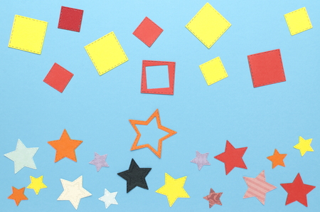 Lots of colorful squares and stars made of paper on blue backgroundの写真素材