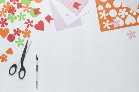 Multi-colored shapes cut from paper, scissors and a scalpel on a white background. The view from the topの写真素材