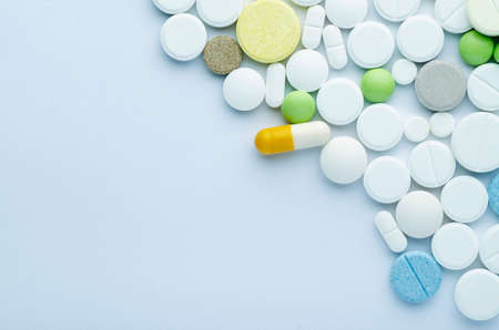 tablets of different shapes and colors on a blue background close upの写真素材