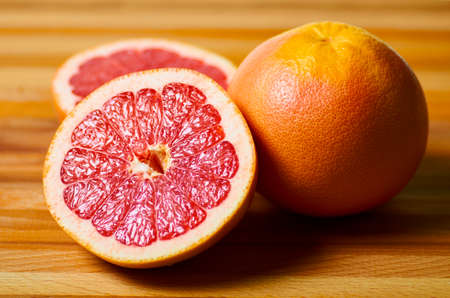 sliced juicy red grapefruit on a boardの写真素材