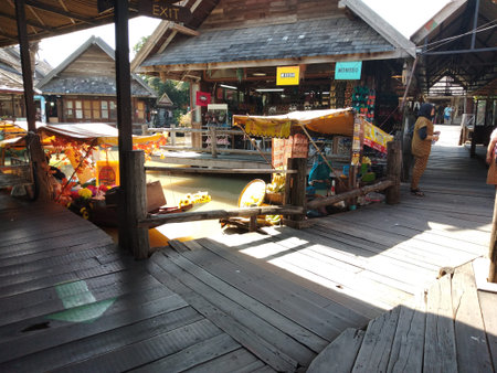 Traditional floating market in Thailand offering diverse local foods and handmade crafts from boats along the canalのeditorial素材