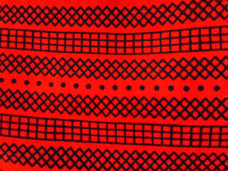 Red geometric textile pattern with symmetrical ethnic motifs and decorative woven traditional design