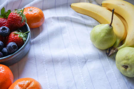selective focus of mixed fresh fruits, strawberry, blueberry, banana orange and pear, copy spaceの写真素材