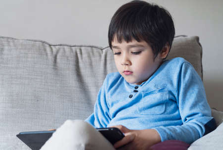 Kid self isolation using tablet for his homework,Child doing using digital tablet searching...