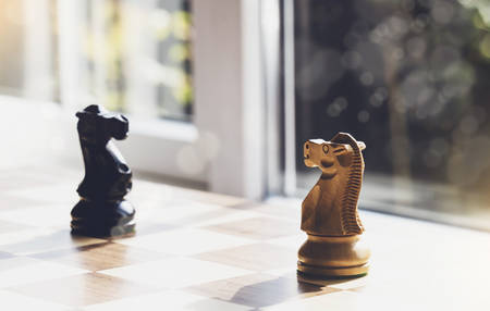 Selective focus of wood knight chess on board game with blurry background, Business leader and confrontation solve problems concept, Chess horse on board with copy space の写真素材