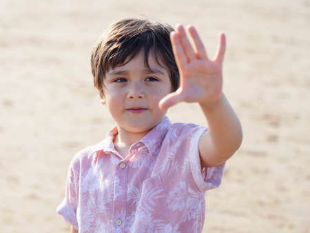 Selective focus of  little boy showing five fingers, Portrait kid primary school counting number five, Child showing five numbers with fingers, Education or Toddler development conceptの写真素材