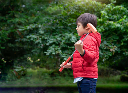 Portrait of Happy child playing mini golf in the park, Active Kid boy playing crazy golf on holiday, Children enjoying his vacation outdoors activityの写真素材