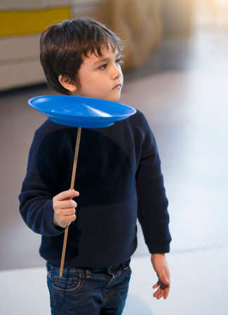 Kid learning how to play spinning plate, Preschool boy balancing bolw on wooden pole, Children learn and play, Indoors or Outdoors activities for kids and familyの写真素材