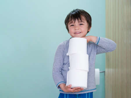 Portrait of Lonely kid with sad face lying down on wooden floor with his teddy bear in playroom at home, Bored child boy looking out with deep in thought, Spoiled childrenの写真素材
