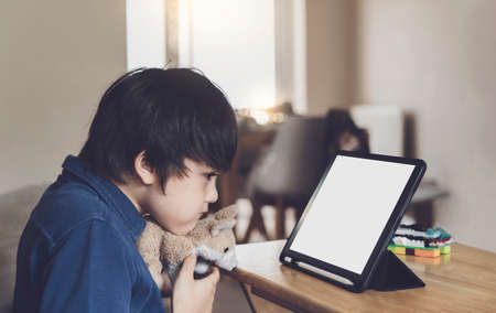Smiling caucasian boy have video call distant class with teacher on  tablet, Happy kid showing his...
