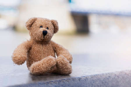 Loney teddy bear sitting by the river, The forgotten bear sitting alone, lost property, Lonely...