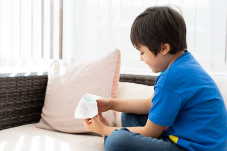 School kid playing with a paper fortune teller,Child boy having fun playing message box toy,Boy...