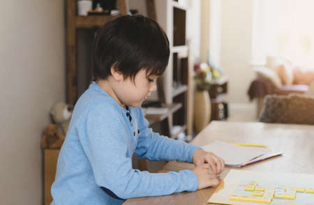 Preschool kid learning English words game,Child boy concentrated with spelling English letter with parent at home. Distance Education, Activity for children for home schooling, New normal lifestyleの写真素材