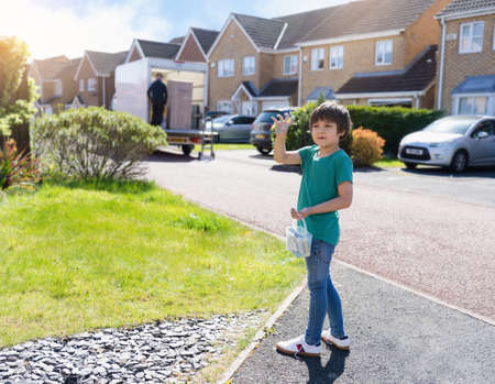 Full lenght portrait happy Kid carrying bucket of colourful chalks, Active boy playing outdoor in sunnyday summer, New normal life child playing around home street area while  Covid-19 Quarantineの写真素材