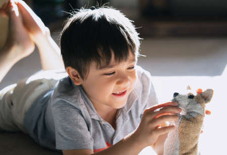 Portrait of school kid siting on table doing homework, Child boy holding pencil writing on paper, Homeschooling , back to school conceptの写真素材