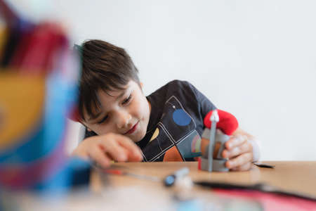 Happy school kid making DIY Easter decorations homework, Child boy preparing and getting ready for Easter hunt  for celebration on School holidayの写真素材