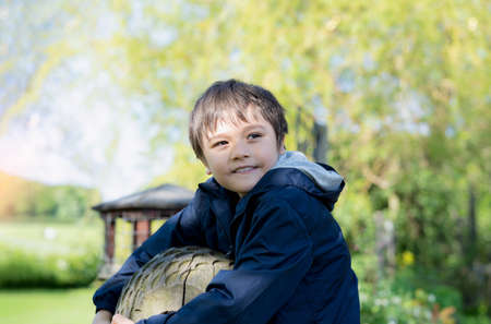 Portrait happy boy with smiling face playing in the park, Active kid having fun in the playground on...