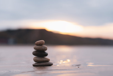 Zen stack stone on sea sand beach with blurry sunset background,Image Landscape pebble rock tower...