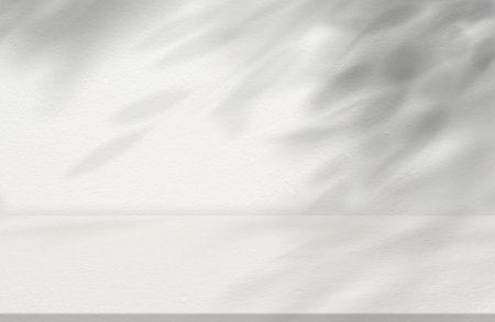 Concrete Wall Texture with Leaves Shadow Overlay Background,Off White Cement with Tropical Branches Tree Shadow on floor.Empty Studio Room Display Backdrop for Cosmetic Product presentationの写真素材