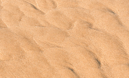 Sand Beach Texture Background in Summer, Top view Brown Sandy Rough Surface with Wave Ripple of Sea Water with copy space for Summer banner design,Natural Sand Stone by the Seaの写真素材