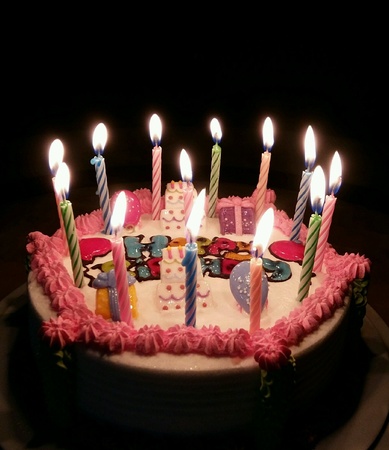 Birthday cake with candle light in the darkの素材