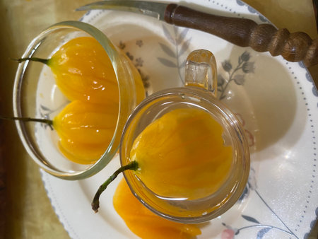 Hot chili peppers in a glass jar with a knife on the backgroundの写真素材
