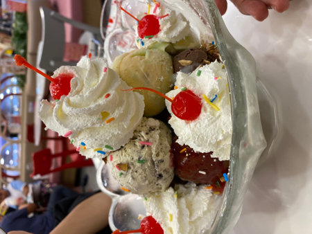 Ice cream sundae with cherry and chocolate topping in ice cream shopの写真素材