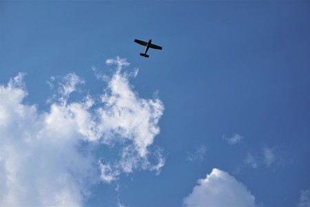 Blue sky and white clouds with silhouette of airplane flying, Summer in GA USA.の写真素材