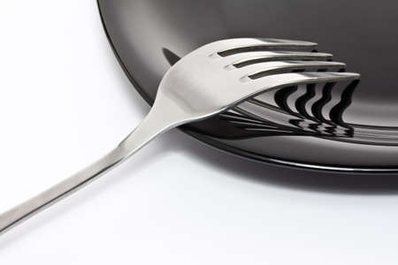 Black high-gloss plate with stainless forkの写真素材