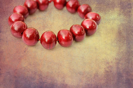 Painted red wooden beads on a grunge backgroundの写真素材