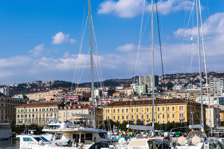 Boats in port of Rijeka, Croatia with buildings in backgroundの写真素材