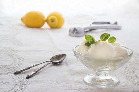 Lemon ice cream with spoons and lemonsの写真素材