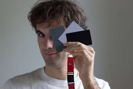 Caucasian boy with white t-shirt playing with gray cards for photography.の写真素材