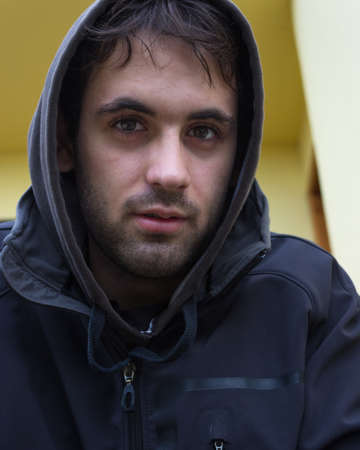 Young white boy with black hoodie and short beard. Vertical imageの写真素材