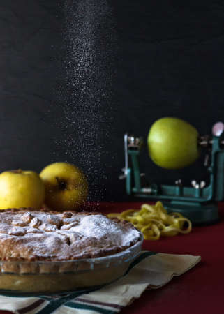 Apple pie with sugar rain. Black background with apples. Food conceptの写真素材