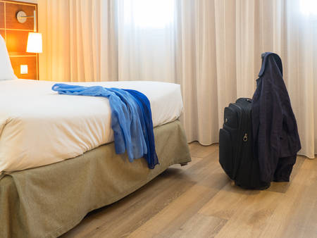 Black travel suitcase in the bedroom and window curtain background - Relaxing time, holidays, weekend and traveling concept.の写真素材