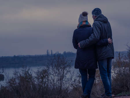 Couple in love contemplating a lake one winter afternoon. Romantic conceptの写真素材
