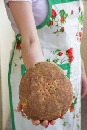 Cropped view of woman holding cut whole grain bread