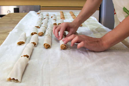 Woman making cannelloni in her kitchen. Home cooking concept.