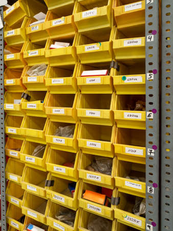 Storage equipment. Many yellow drawers on shelves for storing small tools and items at home, in the...