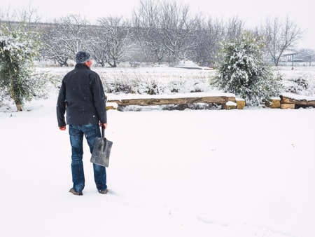 Man with shovel to remove snow from the trail after a snowstorm. Winter conceptの写真素材