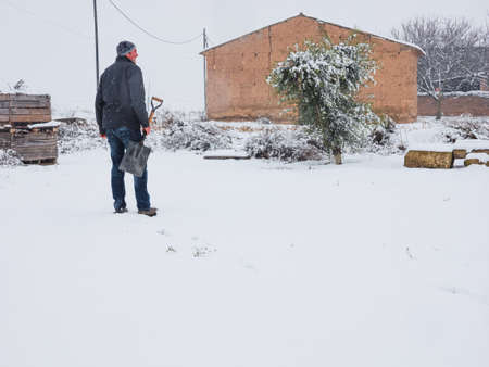 Man with shovel to remove snow from the trail after a snowstorm. Winter conceptの写真素材
